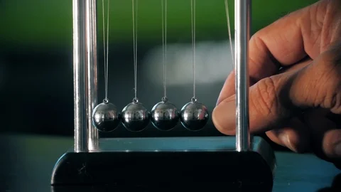 Newton's cradle in motion, five-ball system in one-ball swing. Close up Stock Footage 109455469
