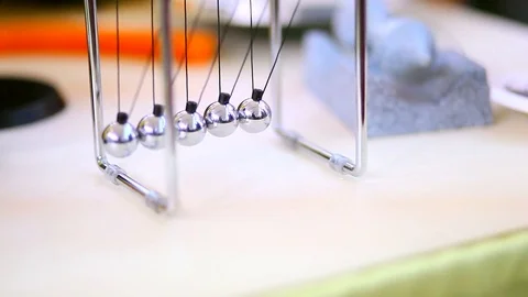 Newton's Cradle with silver spherical metal balls that swinging Stock Footage 72389583