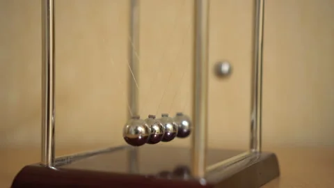 Newton's desk cradle on the table is moving. Balls beat by inertia 库存影片 141384306
