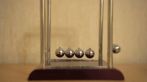 Newton's desk cradle on the table is moving. Balls beat by inertia Video stock 141384340