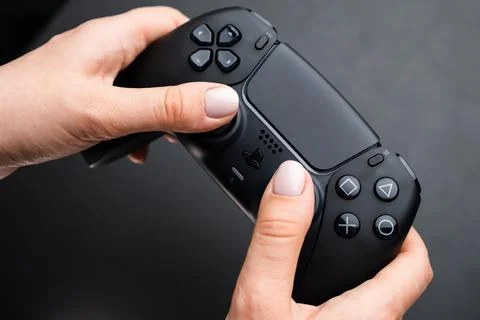 Nex generation game controller in womans hand on the black background Stock Photos