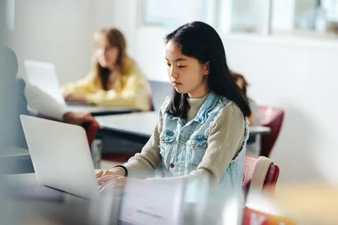 The next big coder: Young girl sits in a coding class, working on a task us.. Foto stock