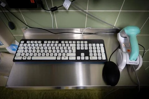 Next to a black computer keyboard is a green barcode scanner Stock-Fotos