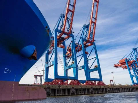 Next to a container ship there are large container cranes for loading and ... 写真素材