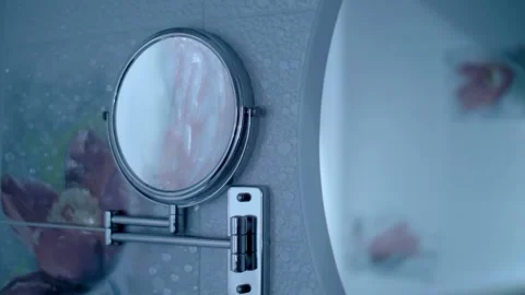 Next to the large round mirror there is small shaving mirror with magnification Stock Footage 297754342
