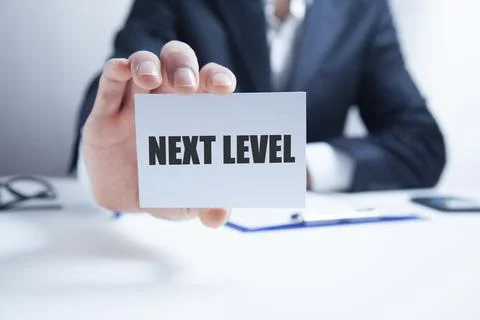 Next level text on card on man hand Stock Photos