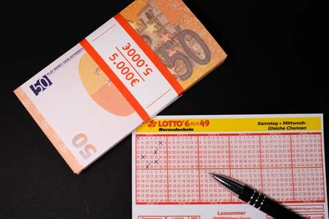 Next to a lottery ticket is a stack of 50 euro bills Stock Photos