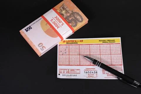 Next to a lottery ticket is a stack of 50 euro bills Stock Photos