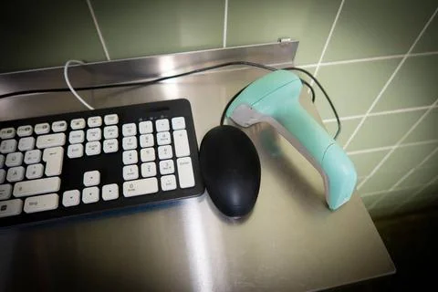 Next to one black computer keyboard is a green barcode scanner Stock-Fotos
