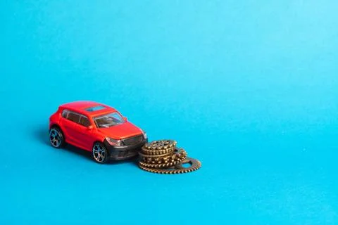 Next to the red car is a stack of metal gears Stock Photos
