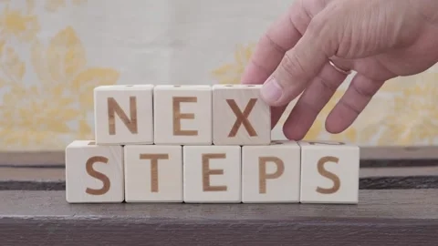 Next steps, motivational phrase, laying out  by hand from letters Stockbeeldmateriaal 342135070