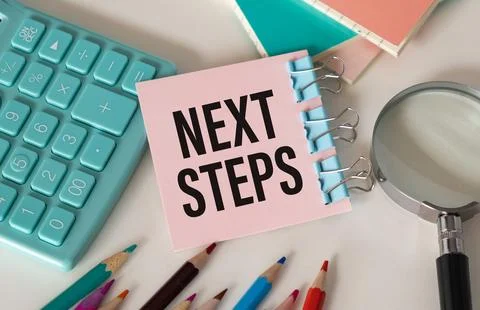 NEXT STEPS text on white desk with tablet pc and calculator Foto stock