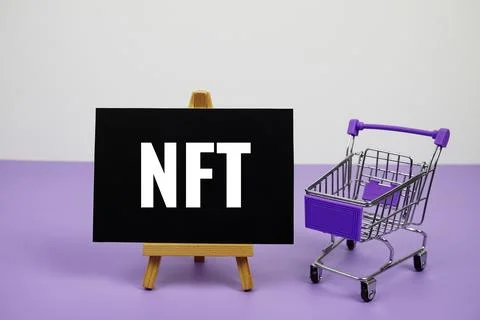 NFT text message and trolley shopping cart on purple background Stock Photos