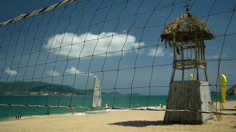 Nha Trang - View of the beach seen through volleyball net in sunny day. Panning Stock Footage 73376174