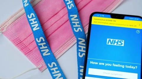 NHS app. App that help to identify COVID-19 symptoms. Face mask, NHS lanyard and Stock Footage 141158099