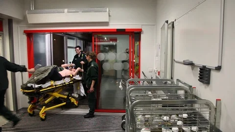 NHS A&amp;E paramedics arrive with patient on gurney Stock Footage 97502561