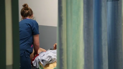 NHS A&amp;E unidentifiable nurse treating patient close Stock Footage 97502865