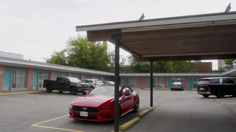 Niagara Falls, Canada - September 03, 2026: Red convertible under a motel Stock Footage 345539888