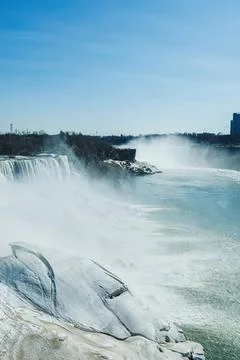 Niagara falls in full flow with mist and blue sky Stock Photos
