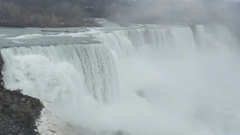 Niagara falls gushing over falls in slow motion at winter misty water splashing Stock Footage 151950752