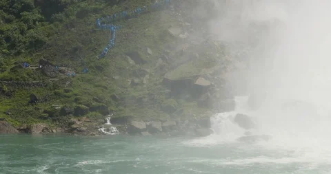 Niagara Falls tourists hiking down cliff to river water edge misty 4K Stock Footage 128989335