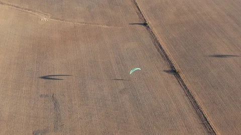 Nice aerial drone shot tracking paramotor having shadow while flying over Video stock 117129736