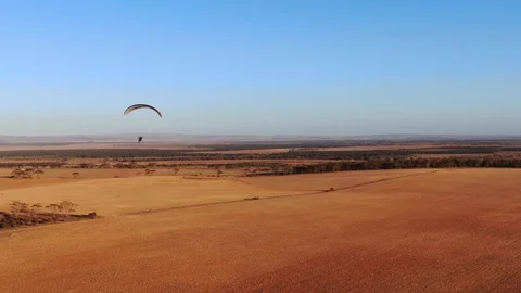 Nice aerial view tracking paramotor flying above crop field in summer time Video stock 116565869