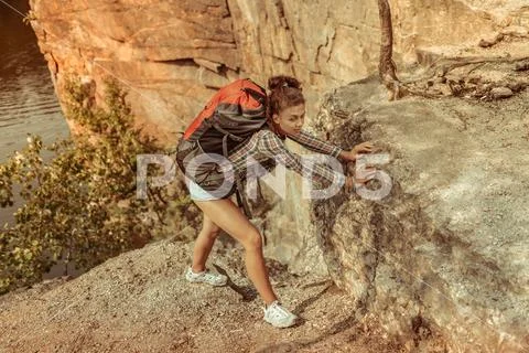 Nice attractive fit woman climbing a cliff Stock Photos