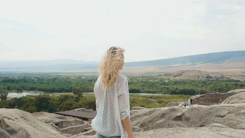 Nice attractive lady with long blond flying hair looks at wonderful view of Stock Footage 105968653
