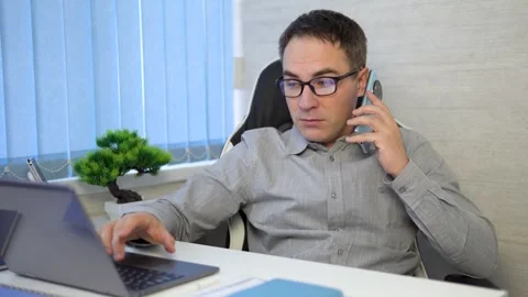 Nice attractive worried guy tech expert geek nerd talking on phone discussing Video stock 298204383