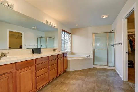 Nice bathroom with lots of space. Modern brown cabinets, double sink Stock Photos