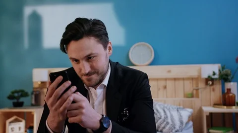 Nice bored young man using dating apps, inventing message. Guy chatting with Stock Footage 105623490