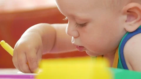 A nice boy of 2 years draws on a magnetic drawing board. He has great Stock Footage 78611356