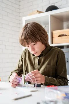 Nice boy constructing a robot car playing with lights Stock Photos