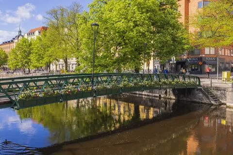 Nice bridge over the river, decorated with flowers, overlooking the city center. Fotos Stock