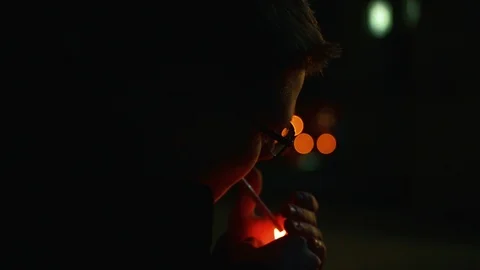 Nice Caucasian guy in glasses lighting cigarette in the street of big city Stock Footage 91122586