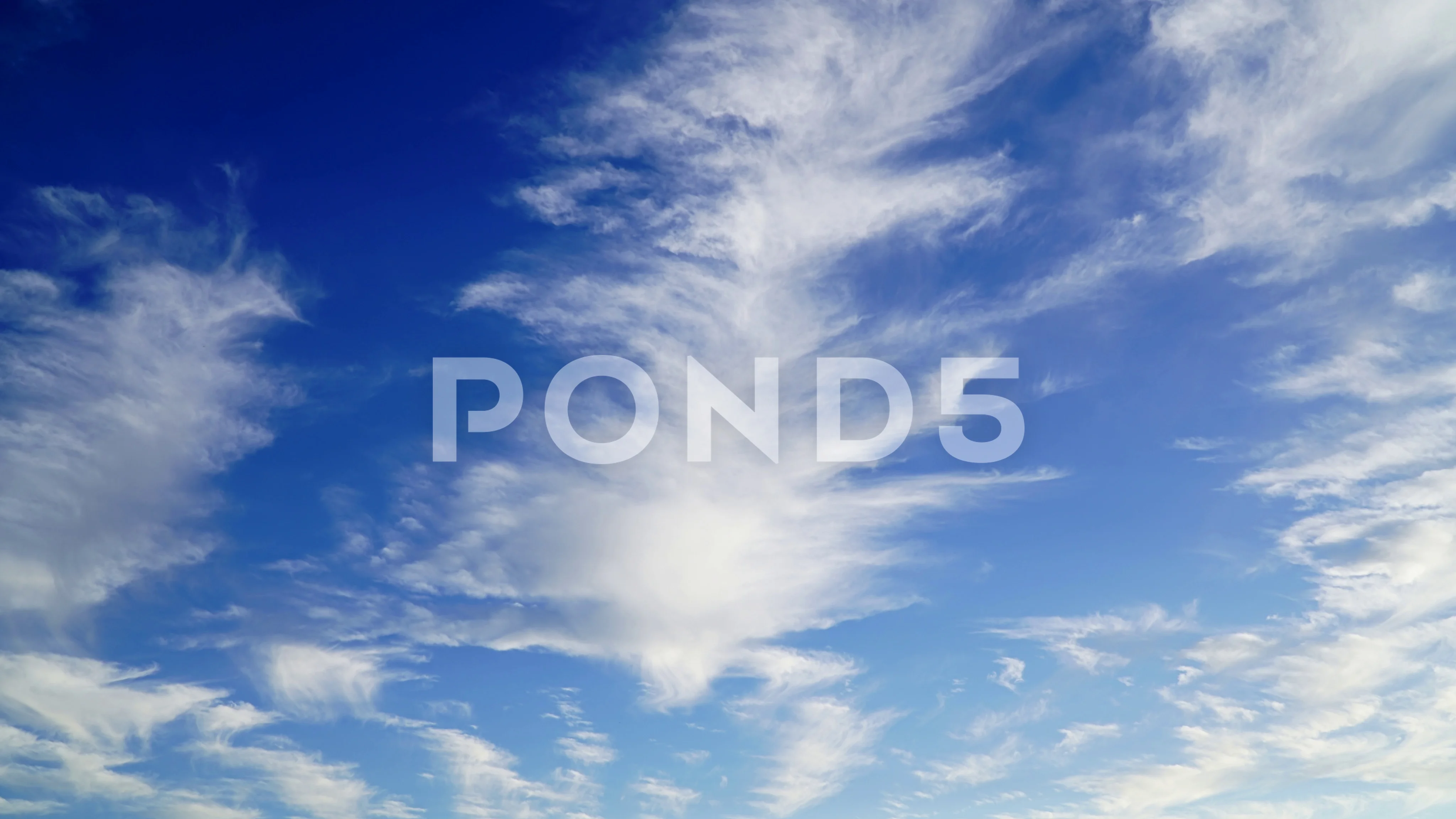 Hazy cirrostratus clouds in light blue sky Stock Photo