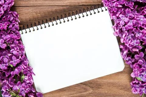 Nice composition of a blank notebook and lilac flowers on the brown wooden Stock Photos