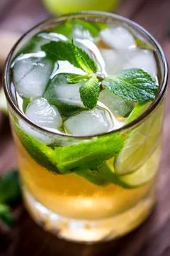 Nice composition of Mojito glass macro with ice cubes, mint and lime on the Stock Photos