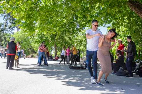 Nice couple dancing together by the performans of the street musicans Stock Photos