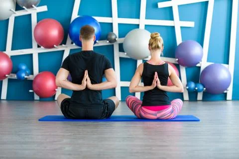 Nice couple doing yoga in a studio. Young people in yoga class in Reverse Pra Foto stock