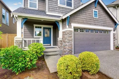 Nice curb appeal of two level house, mocha exterior paint and concrete drivew Stock Photos