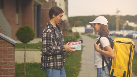 Nice Cute Lady Courier in Special Uniform, Carrying the Yellow Backpack Delivers Stock Footage 247262400