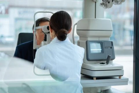 Nice dark haired woman using the optical instrument Stock Photos