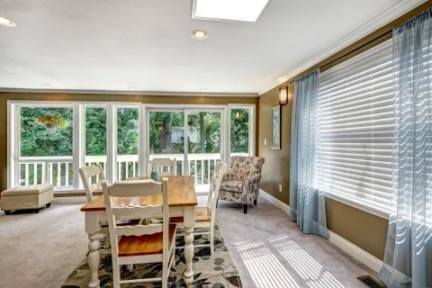 Nice dining room interior with soft blue curtain and floral carpet. White and Stock Photos