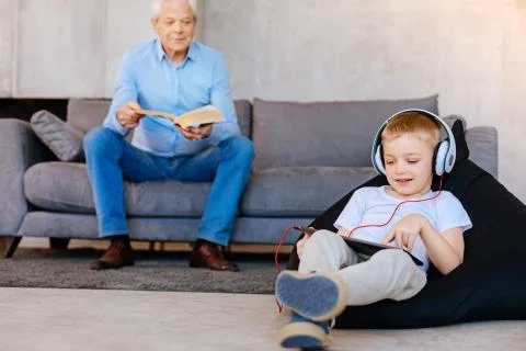 Nice elderly man looking at his grandson Stock Photos