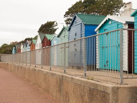 A nice even row of beach huts with fence in front down in dovercourt harwich Stock Photos