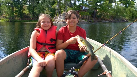 Nice fish.  Two boys with a fish they have caught. Stock Footage 105861014