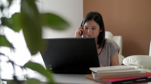Nice girl browsing internet talking over the phone at home 스톡 동영상 49831355