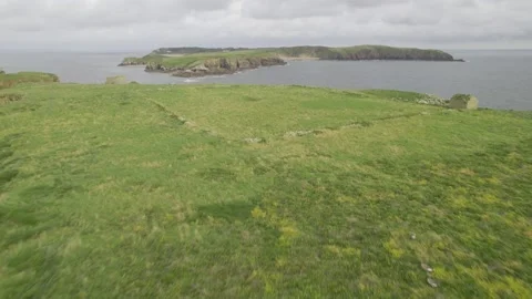 Nice green grass growing on small rocky island, jagged sea coast Video stock 166598072